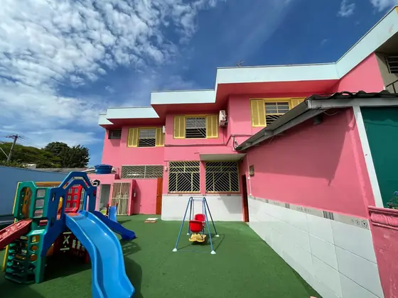 O parquinho visto da entrada, com grama sintética e piso protegido